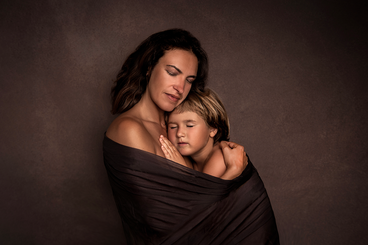 Ritratto madre con bambina avvolte da tulle su sfondo marrone