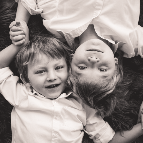 Kids&Family fratelli distesi su tappeto sorridenti bianco e nero