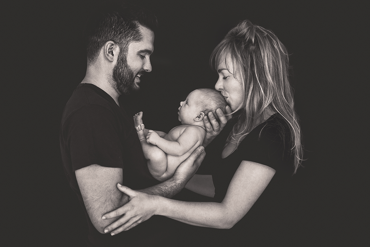 mamma e papà con neonato in braccio in bianco e nero